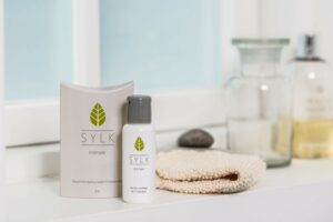 Display of Sylk natural lubricant products in attractive packaging on a bathroom counter.